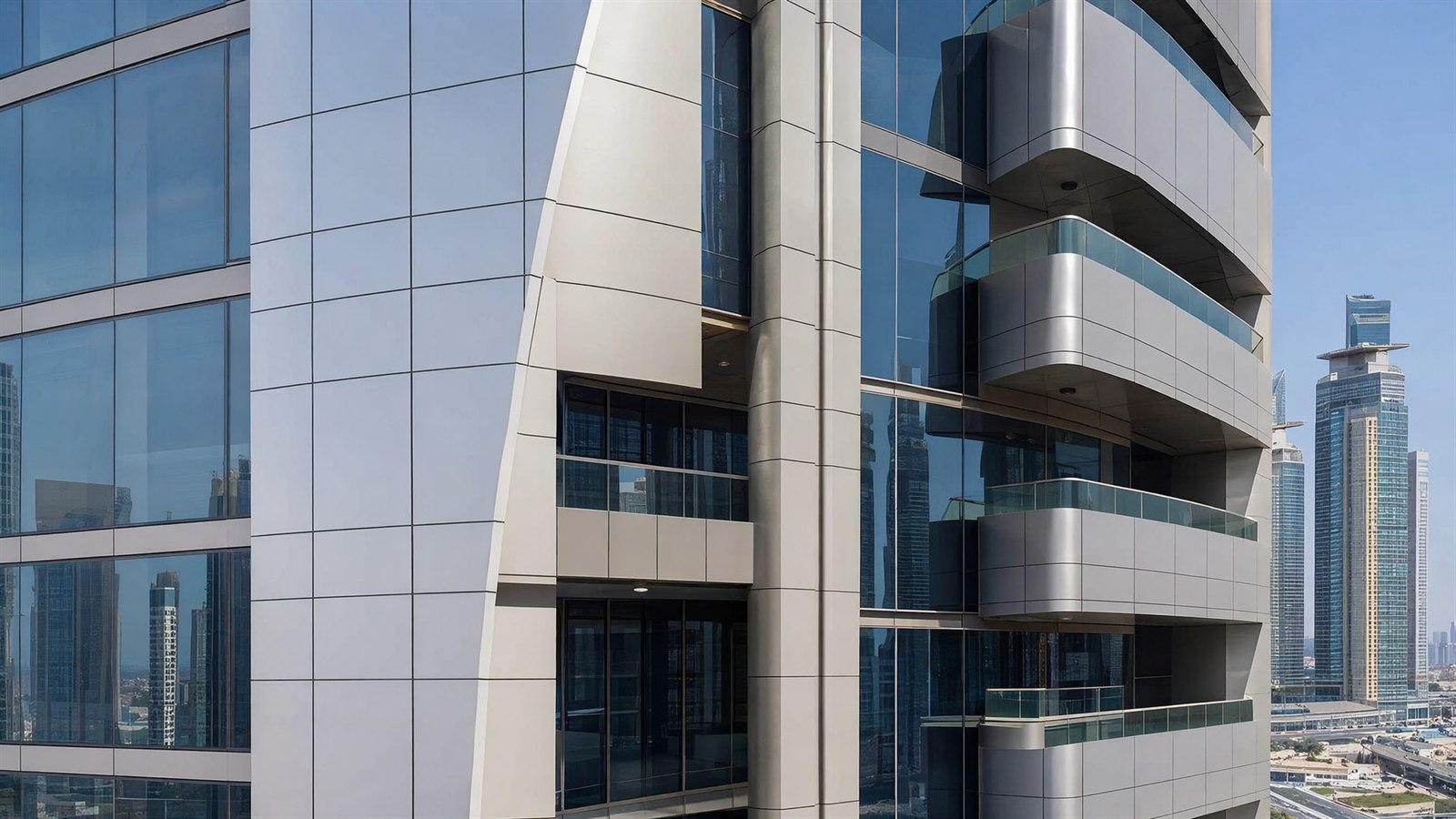 Close view of a Dubai tower facade showing aluminium composite cladding panel joints and glass