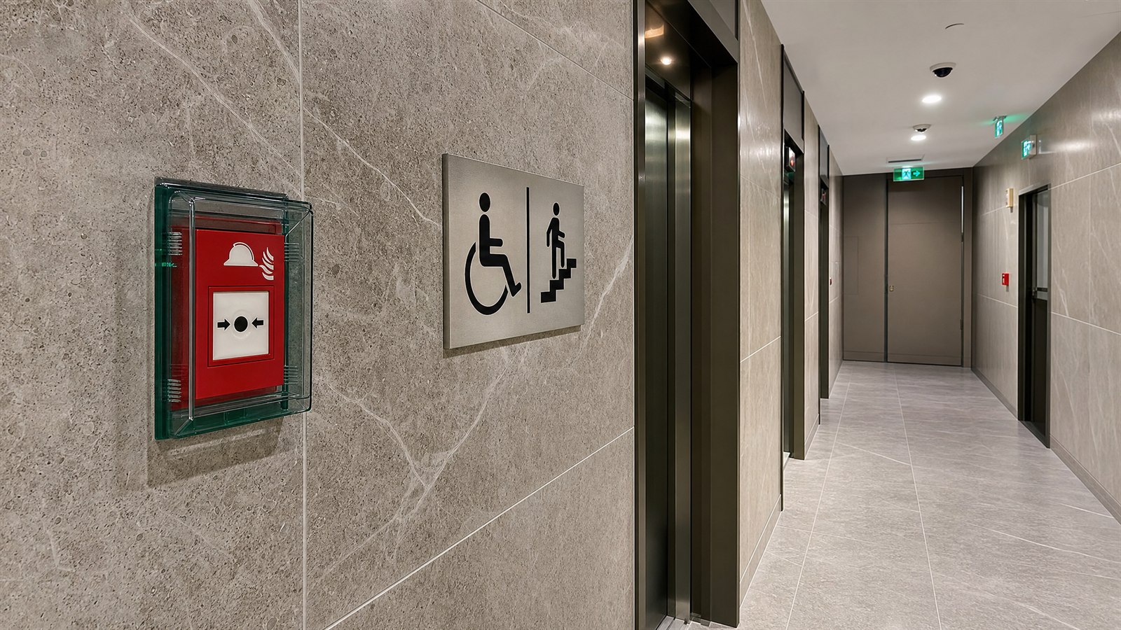 High-rise firefighter lift lobby with a red firefighter call switch behind glass and a refuge-area sign